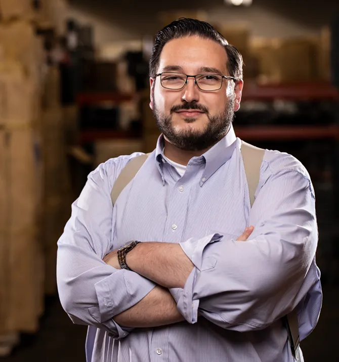 David Reece standing in a warehouse with his arms crossed.